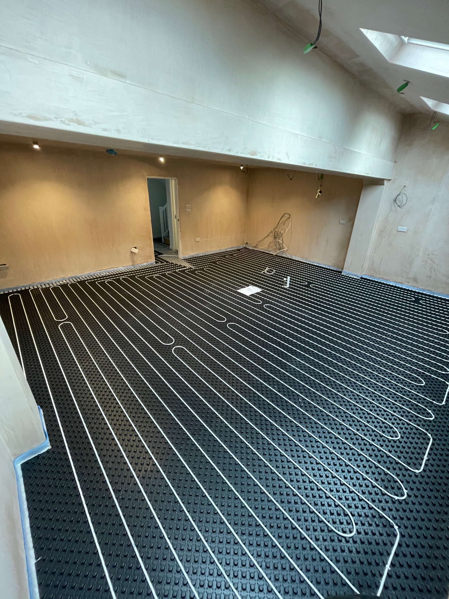 Wet underfloor heating system installed in a large open-plan living area