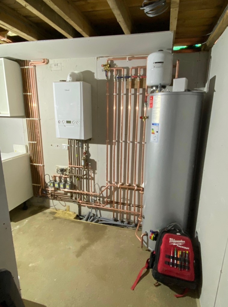 Ideal boiler and unvented hot water cylinder installation with neatly installed copper pipework in West Sussex.